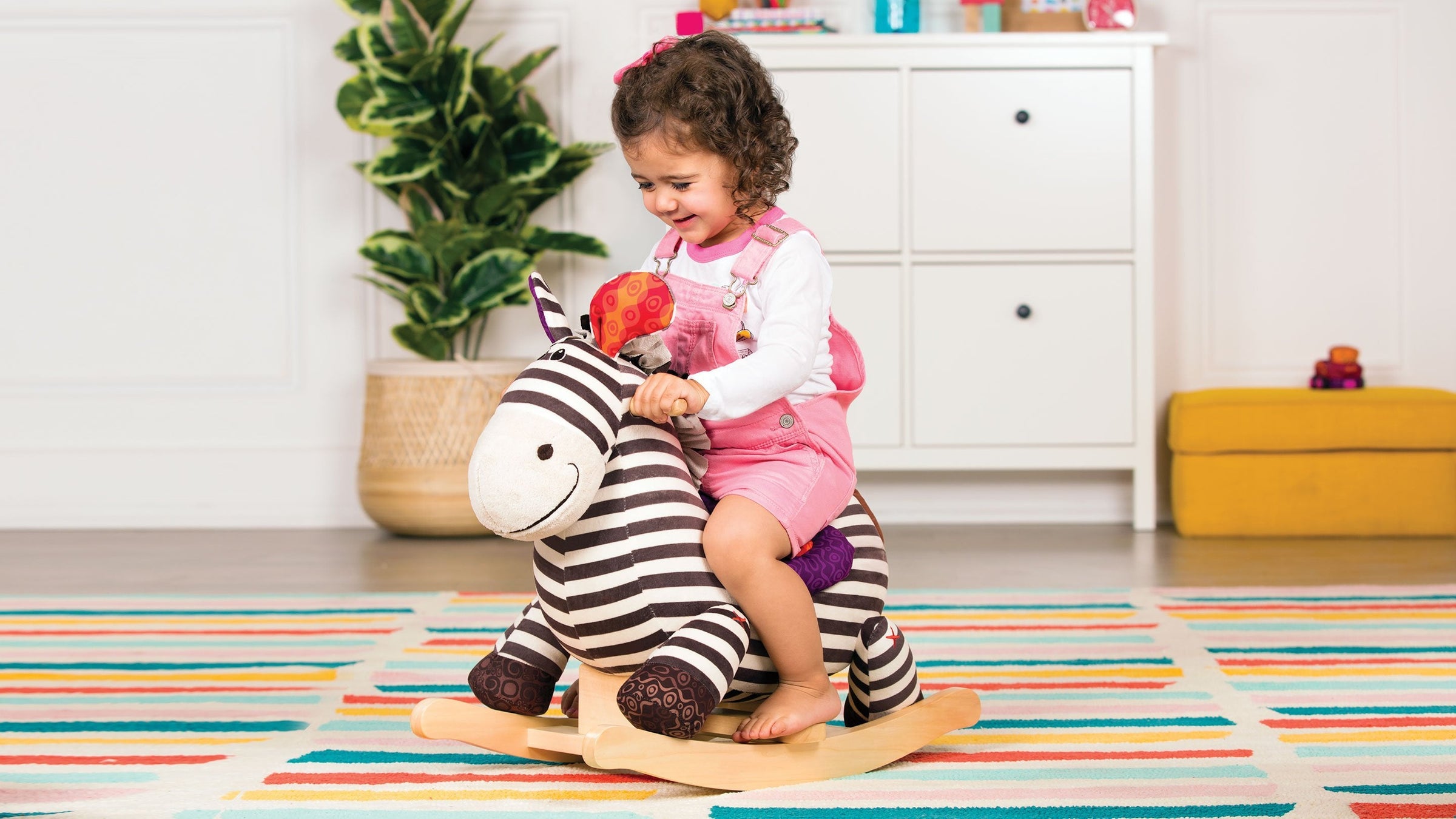 Toddler playing with Zebra Ride-on B. toy